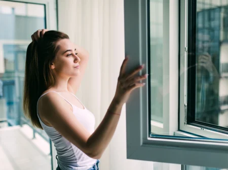 Casement Windows young woman opens plastic window